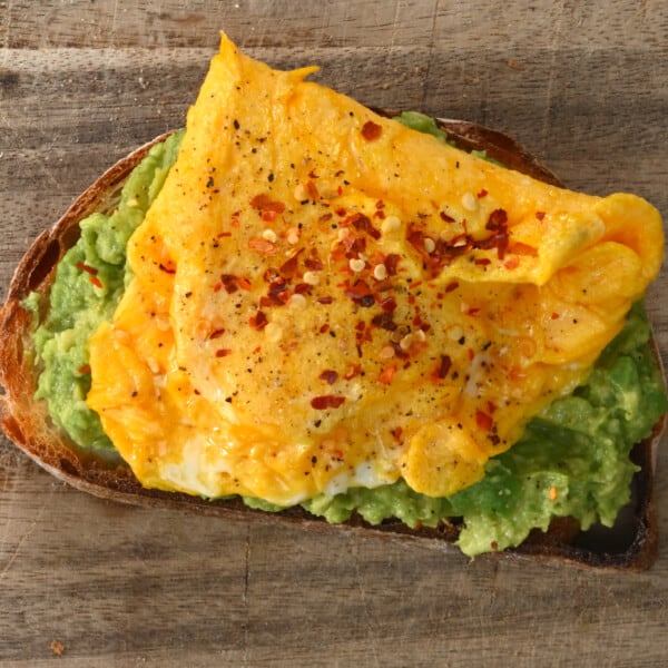 Omelette and avocado sandwich topped with chili flakes