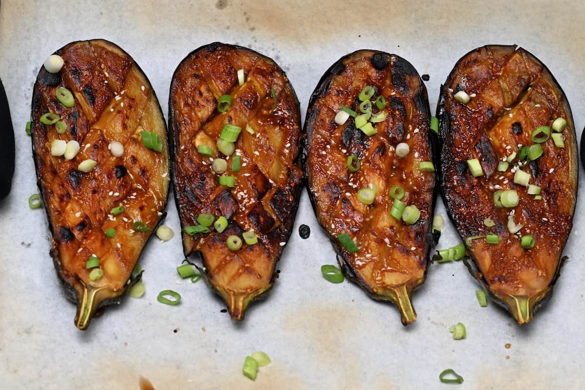 Four miso glazed eggplant halves topped with green onions