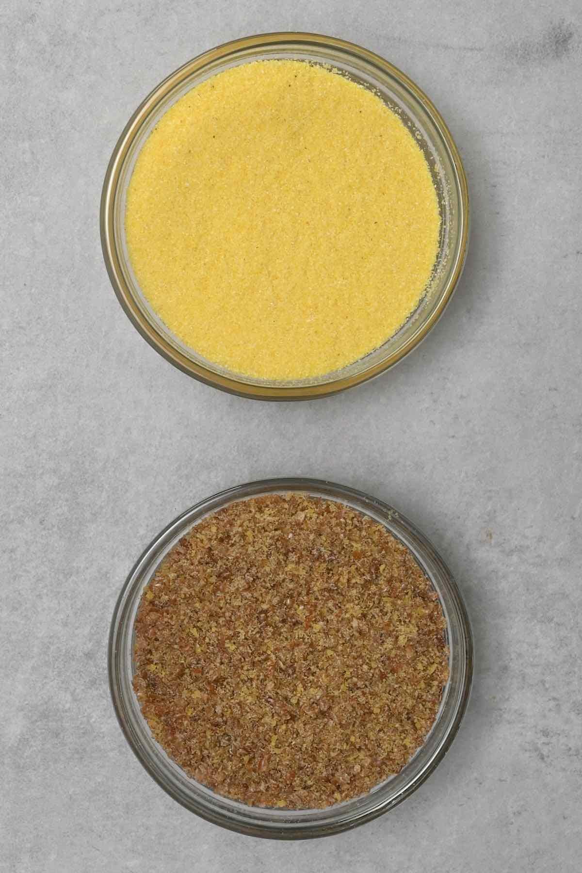 ground flaxseed next to cornmeal in glass bowl
