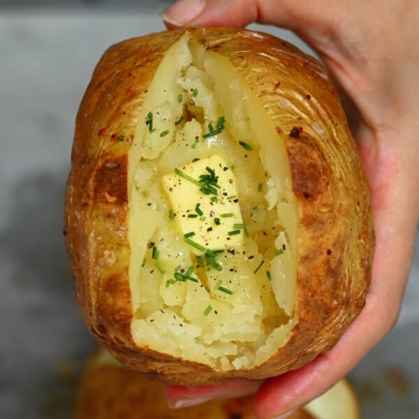 Baked potato with some melted butter topped with chives