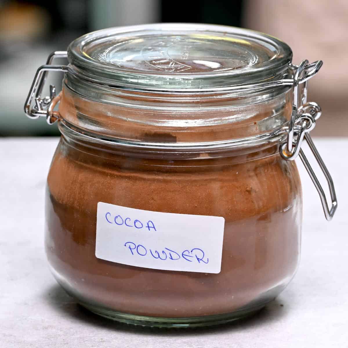 side view of raw cocoa powder in a glass jar