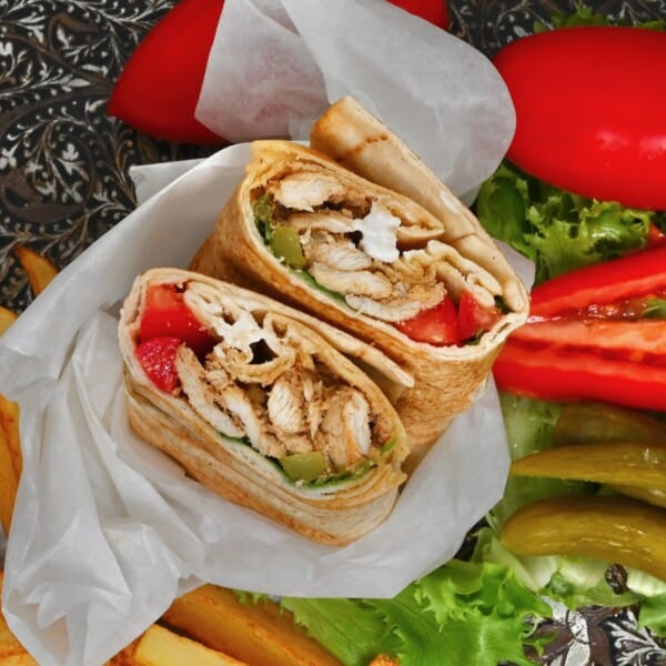 Chicken shawarma prepared into a wrap with vegetables and garlic sauce