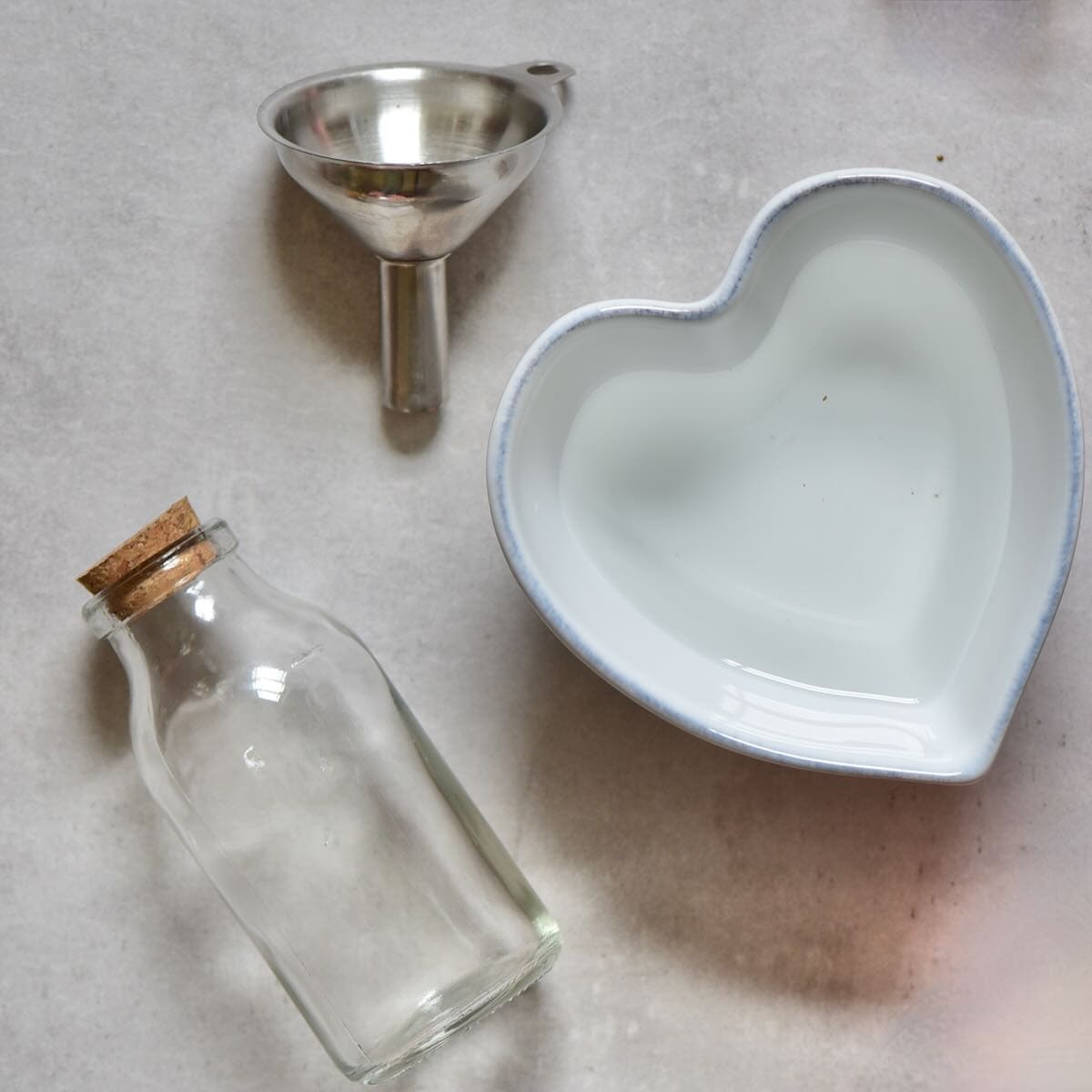 A bowl with rose water, a small funnel and a small bottle