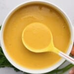 A ladle spooning carrot soup over a serving bowl - 20