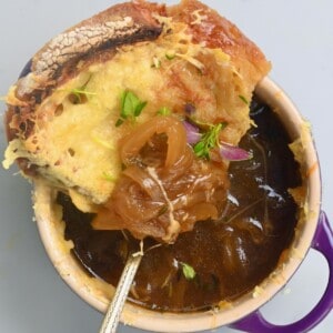 French onion soup in a small bowl topped with cheesy toast
