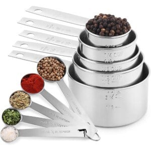 A set of measuring cups and spoons with some spices added to them