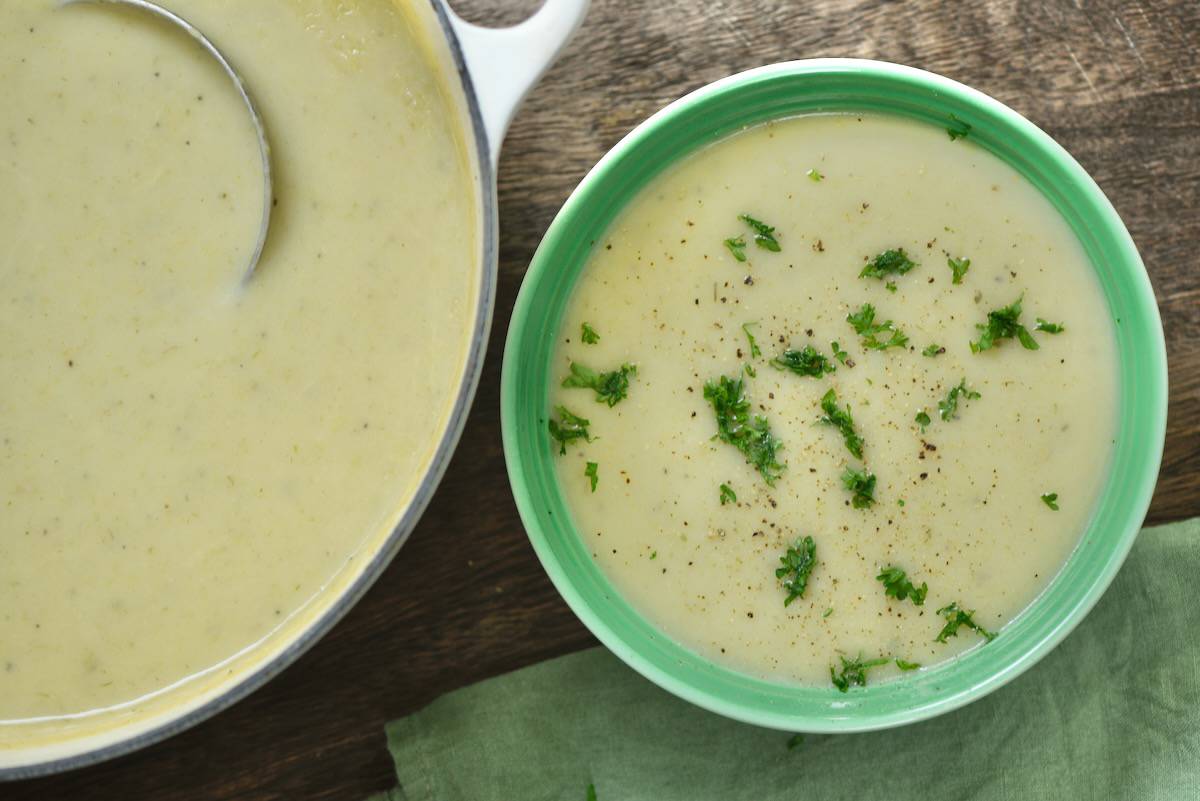 Potato leek soup served in a small bowl and topped with parsley