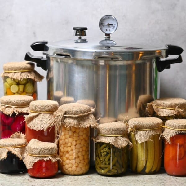 A large pressure canner and several jars with homemade canned food