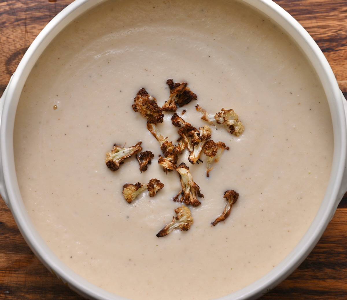 A bowl of homemade cauliflower soup topped with toasted cauliflower florets