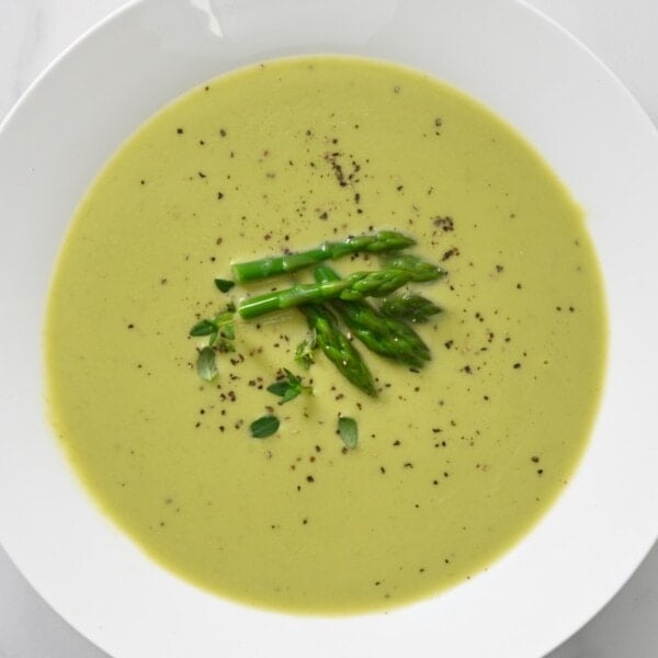 A serving of asparagus soup topped with asparagus tips