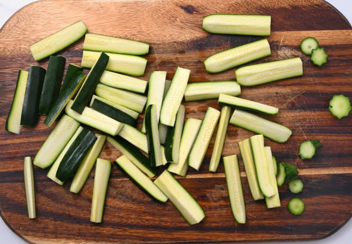 Zucchini cut into sticks on a chopping board