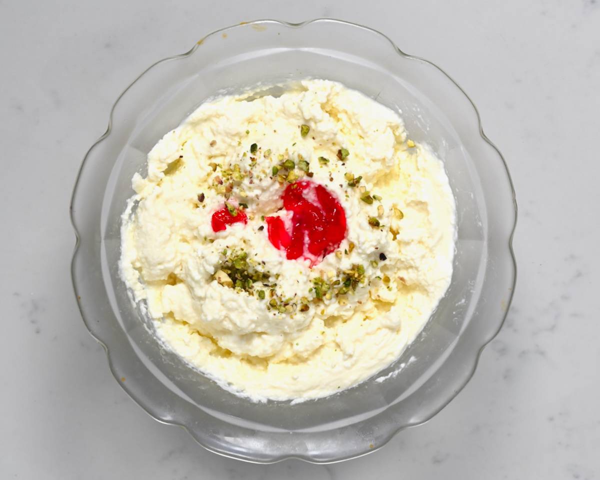 Homemade ashta in a bowl topped with pistachio and cherry