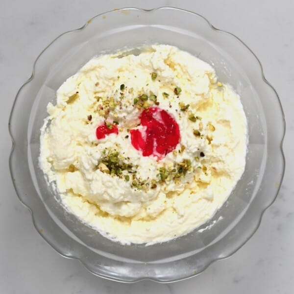 Homemade ashta in a bowl topped with pistachio and cherry