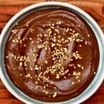 A bowl with chocolate hummus topped with chopped nuts