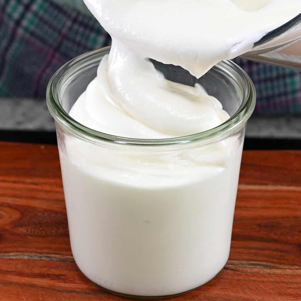 Spooning garlic sauce into a glass container