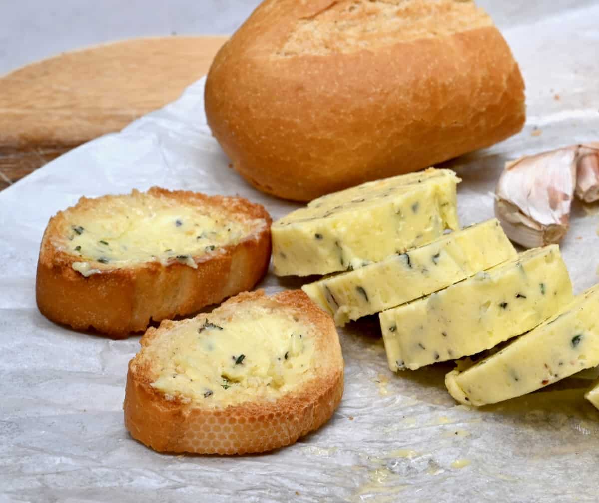 Homemade garlic butter cut into slices with bread slices next to it