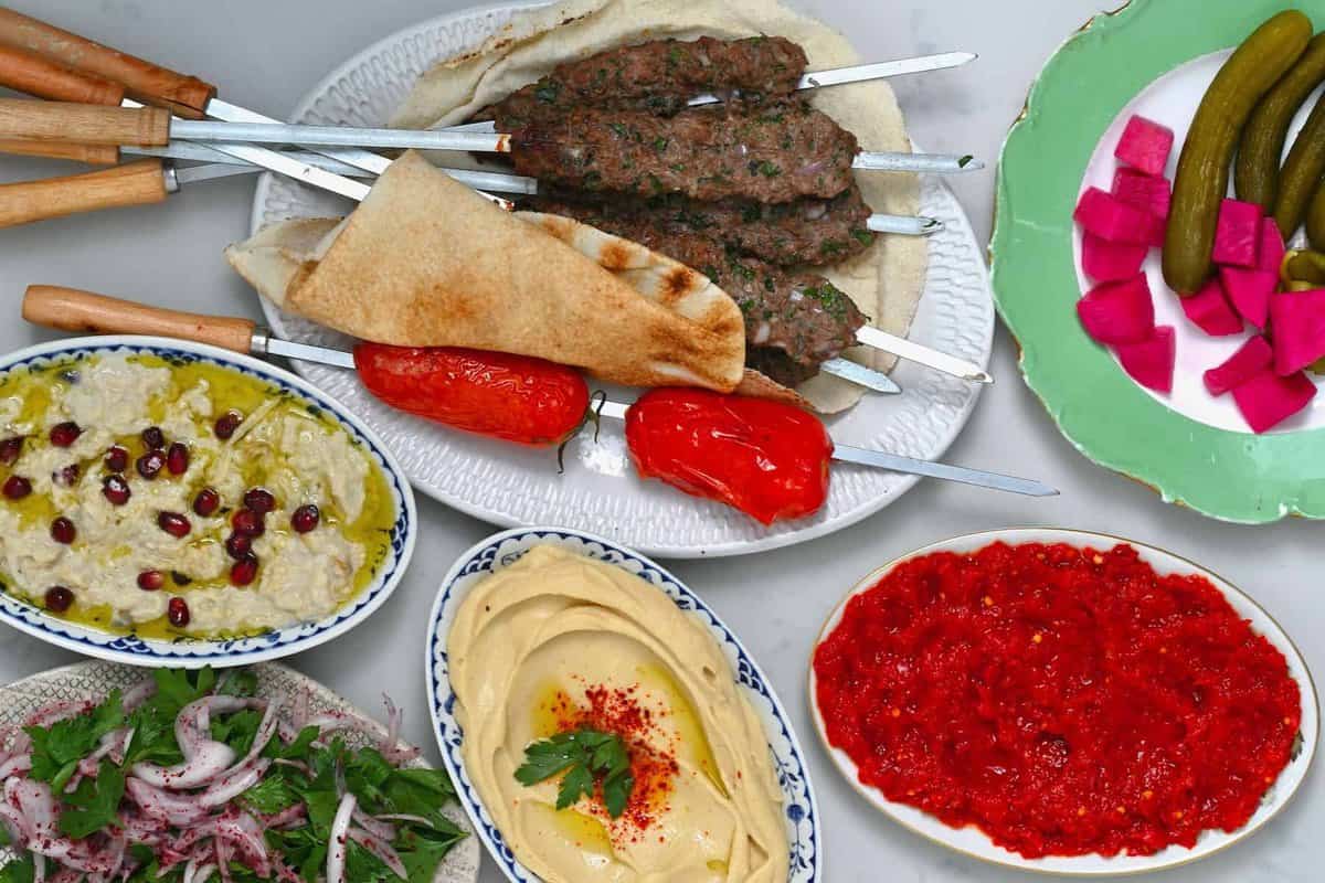A selection of kofta skewers dips and pickles