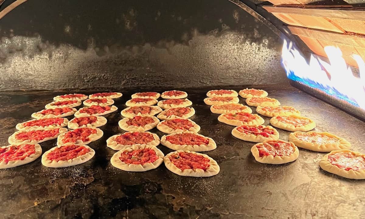 Baking Lebanese meat pies in a pizza oven