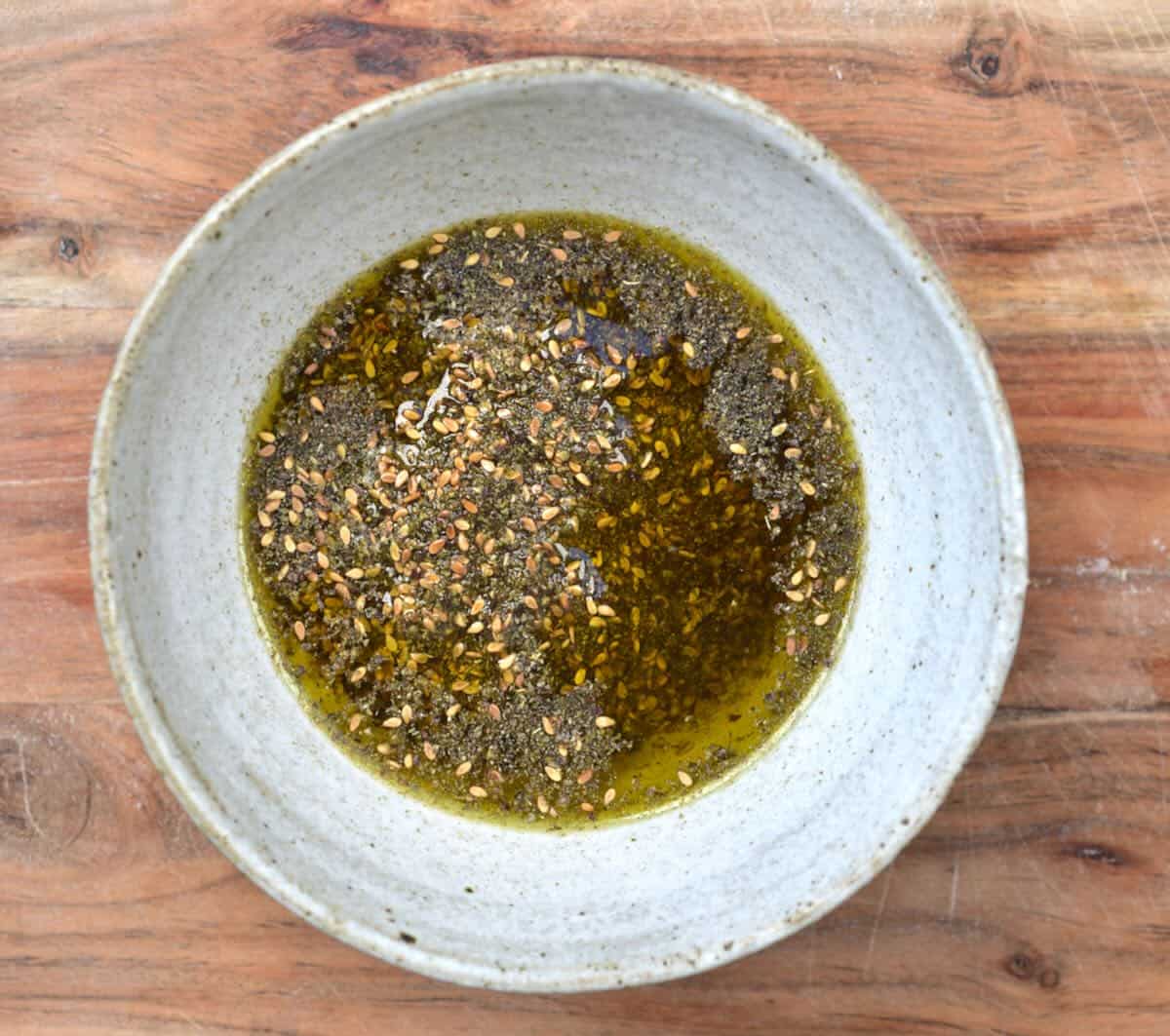 A bowl of za'atar spice and olive oil.
