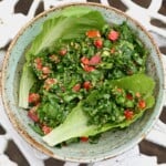 A bowl with tabbouleh and lettuce leaves