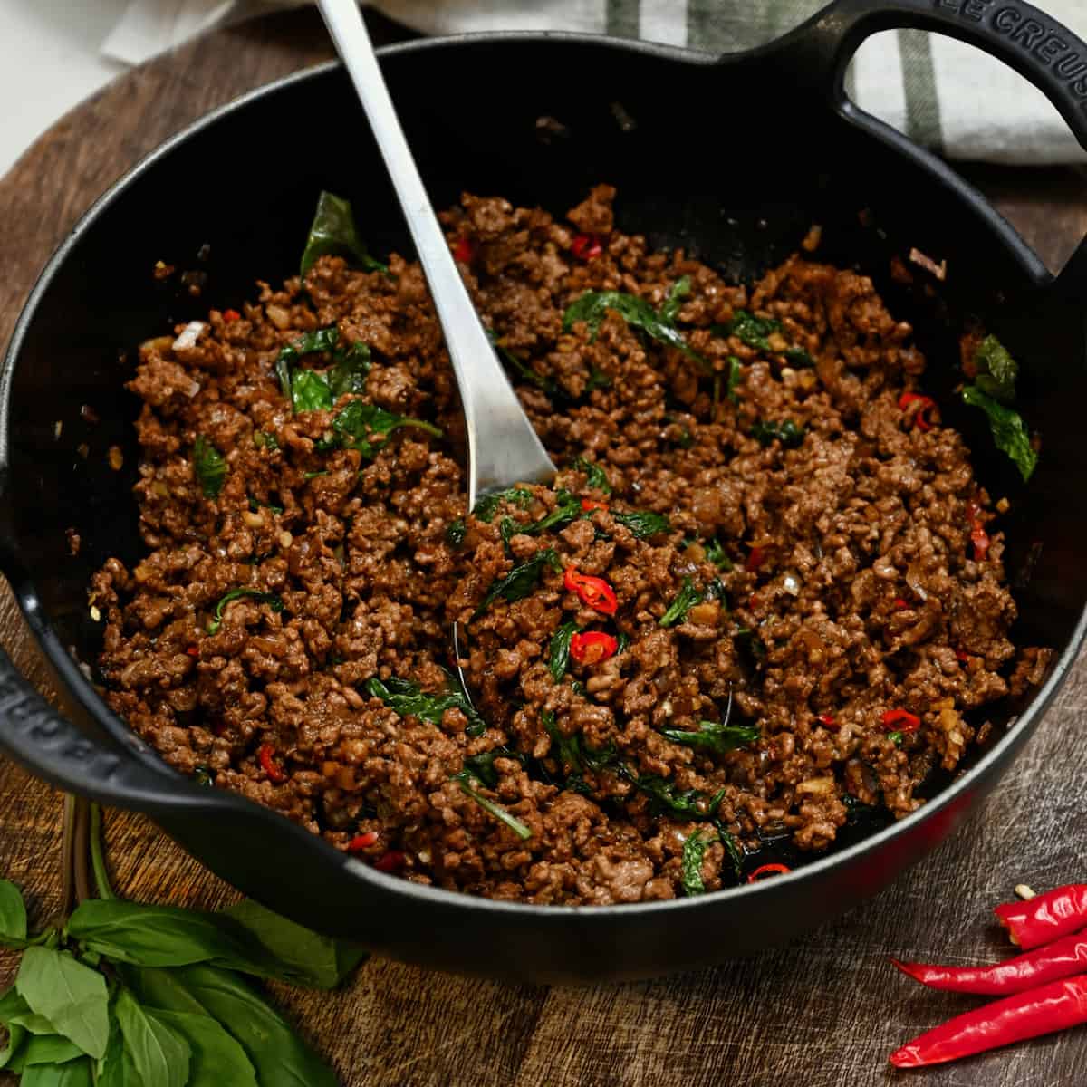 pad kra pao with spoon in skillet