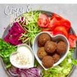 A bowl with falafel and vegetables around it
