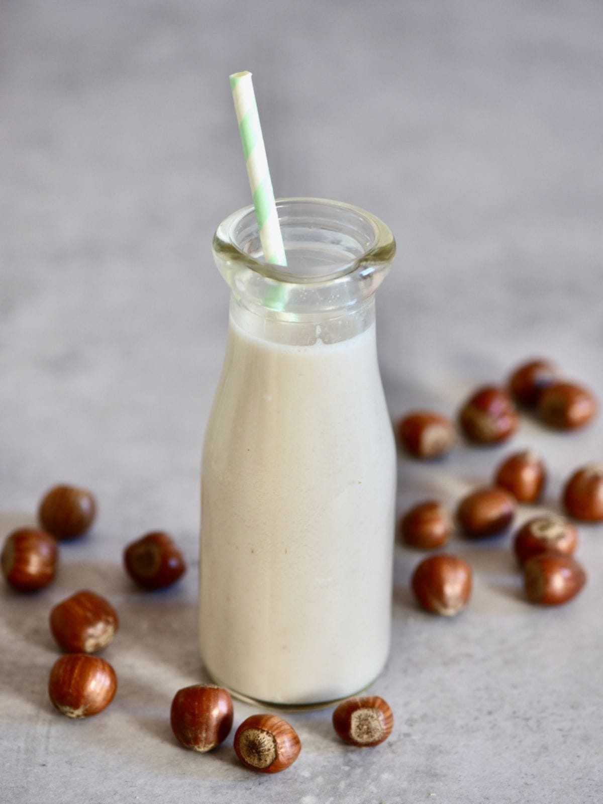 A small bottle with homemade hazelnut milk and a straw