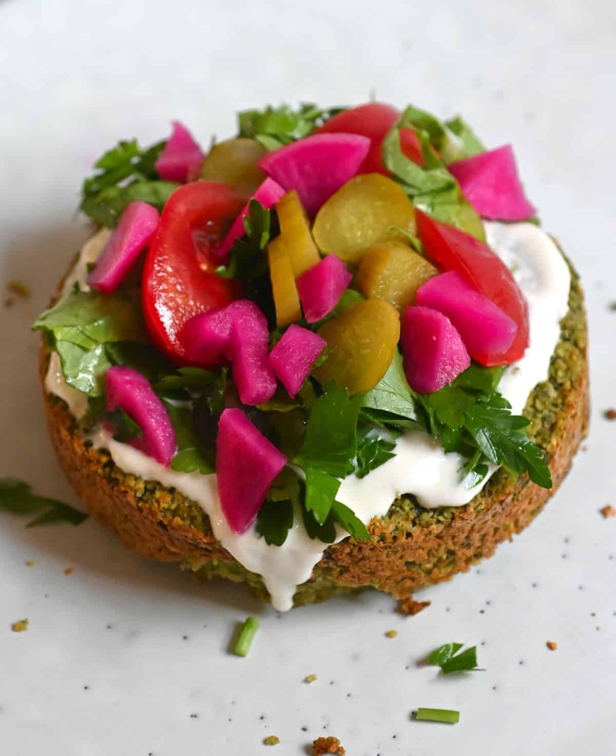 falafel burger patty topped with veggies and pickles