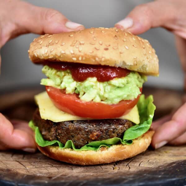 Homemade black bean burger with lettuce, cheese, tomato, avocado and ketchup