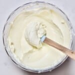 Hoomemade cream cheese in a small container with a spoon dipped in it. - 16