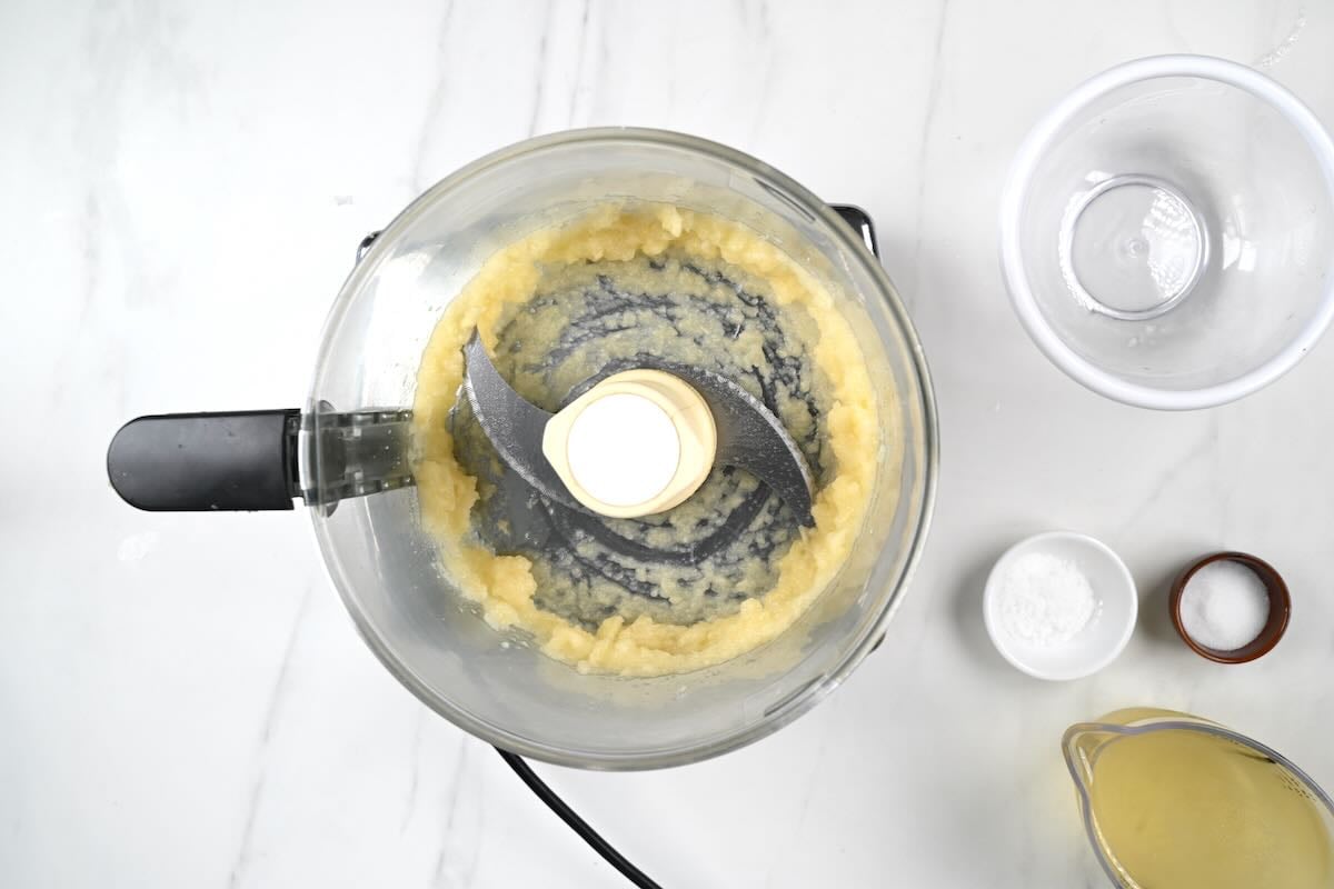 Blending frozen garlic in a food processor.
