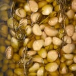 A close up of homemade garlic confit showing the individual cloves in oil. - 16