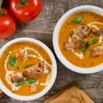 Two bowls with roasted tomato soup, topped with croutons. - 10