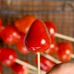 Strawberry tanghulu on a stick, showing the hard candy shell.