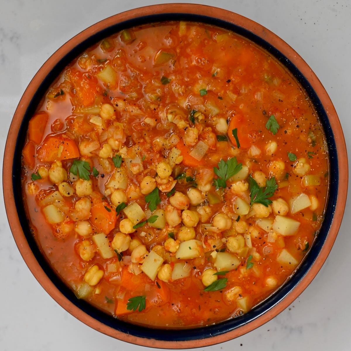 A serving of chickpea soup topped with parsley. - 51