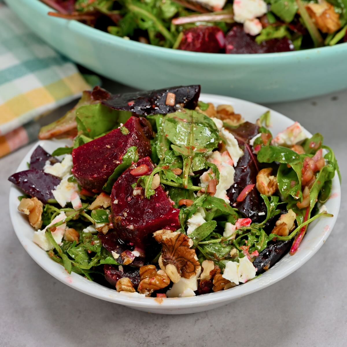 A serving of homemade beet salad in a small bowl next to a larger serving bowl. - 46