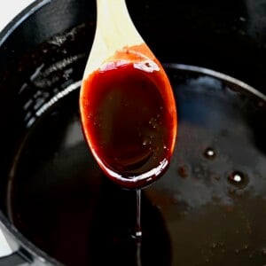 A spoon dripping homemade date syrup in a pan. - 7
