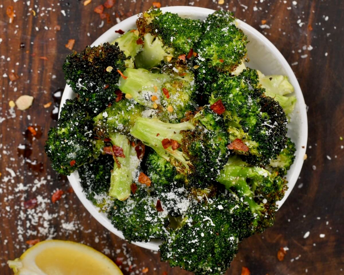 A serving of air friyer broccoli topped with parmesan and chili flakes.