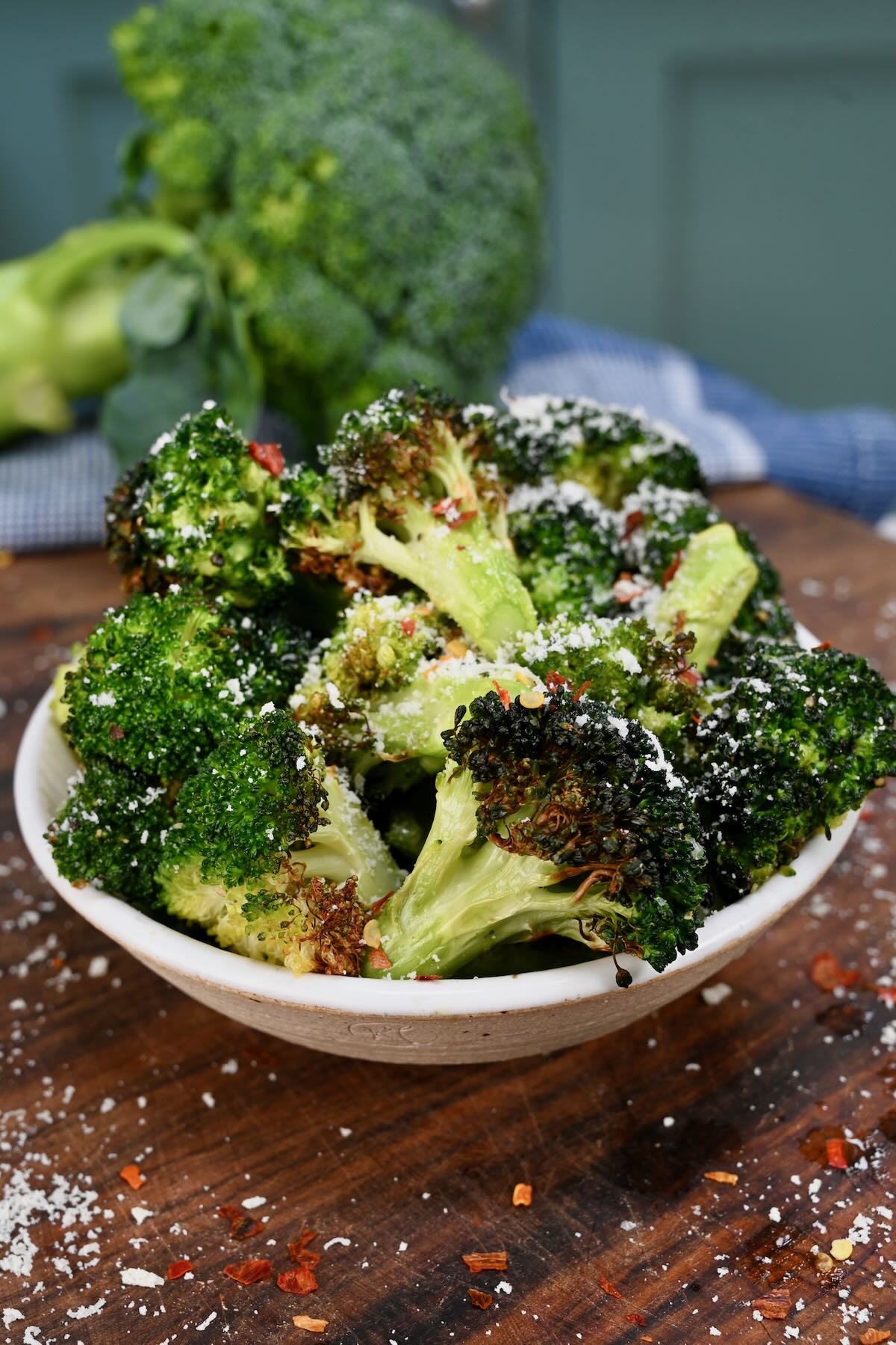 A serving of air fryer broccoli topped with parmesan and chili flakes.