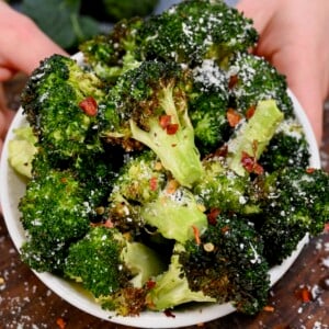 A serving of air fryer broccoli topped with parmesan and chili flakes.