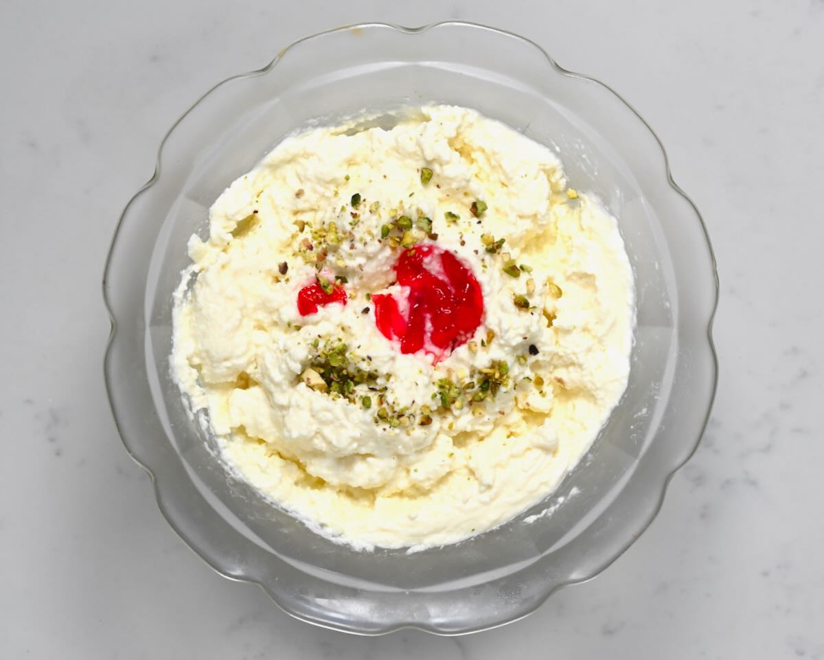 A small plate with homemade ashta topped with rose jam and pistachios. - 2