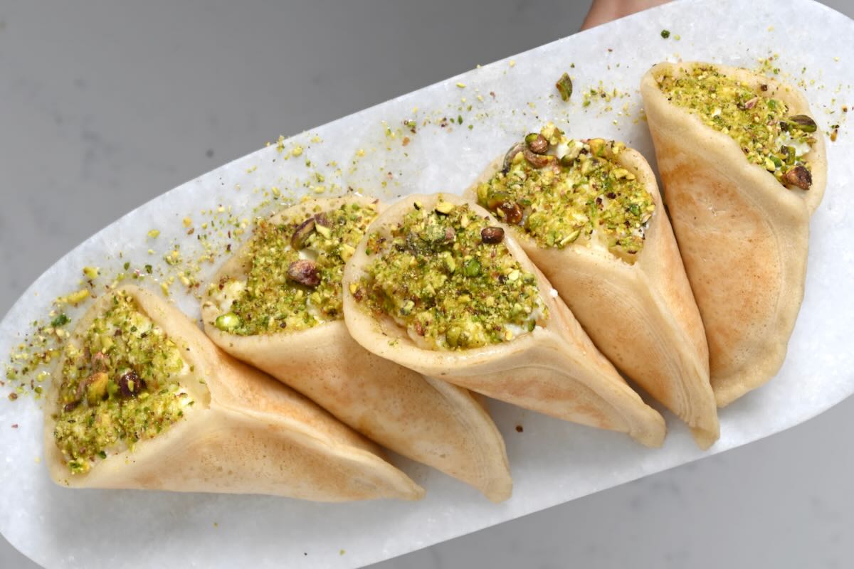 Qatayeh pancakes filled with homemade kashta and topped with pistachios. - 9
