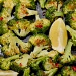 Roasted broccoli on a baking tray with a lemon wedge. - 6