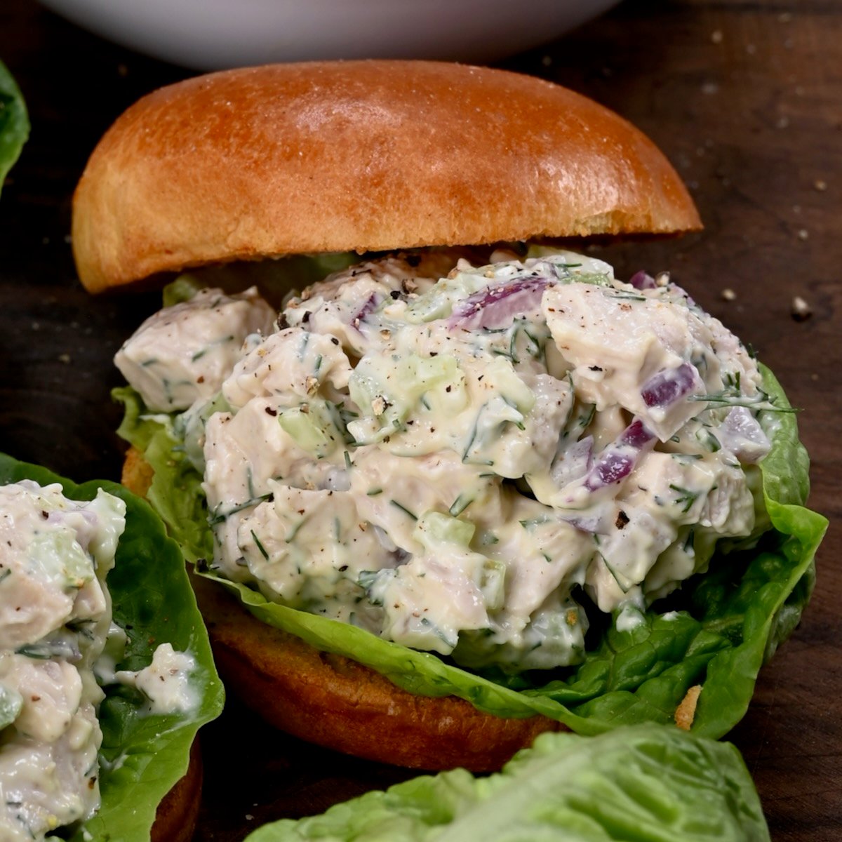 creamy turkey salad served with bread and lettuce leaves.