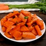 A large serving of roasted carrots topped with some fresh parsley. - 12