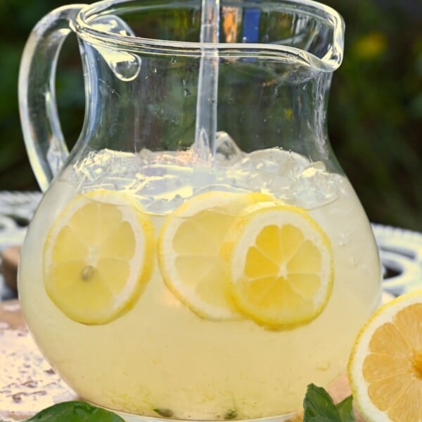 Simple homemade lemonade with lemon slices in a large jug.