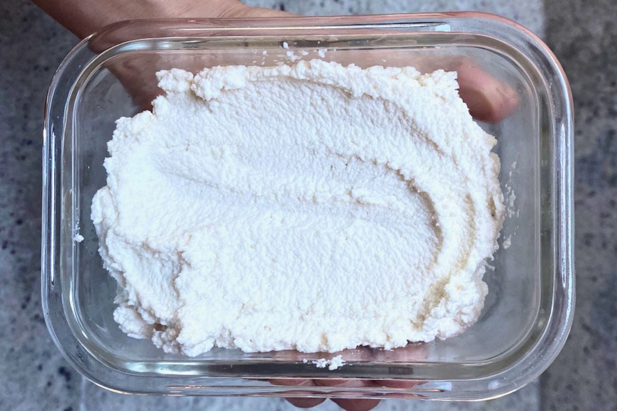 Vegan ricotta cheese in a glass storage container.