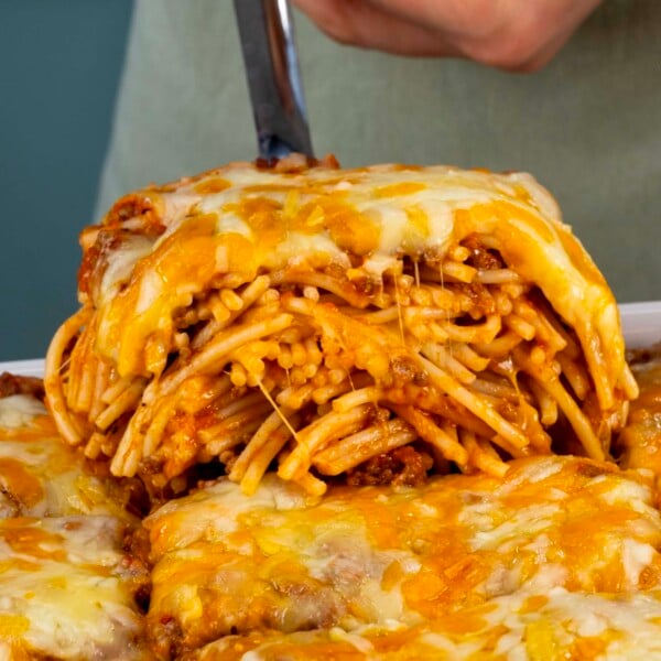 close up side view of baked spaghetti slice on a spatula