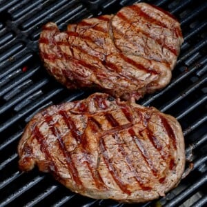 two grilled steaks on grill with grill marks