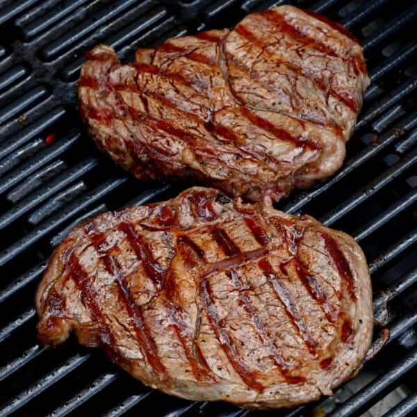 two grilled steaks on grill with grill marks